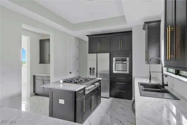 a kitchen with stainless steel appliances granite countertop a stove refrigerator and cabinets