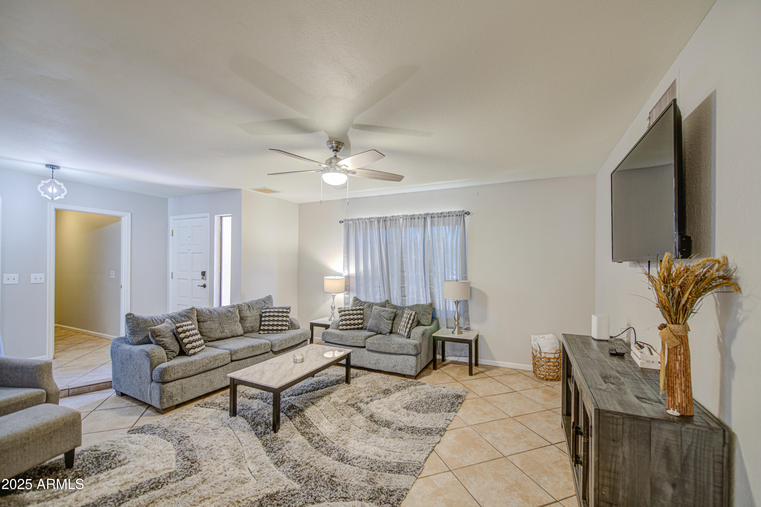 907 West Redfield Road Tempe, AZ 85283 - Photo 3 of 53 a living room with furniture a flat screen tv and a window