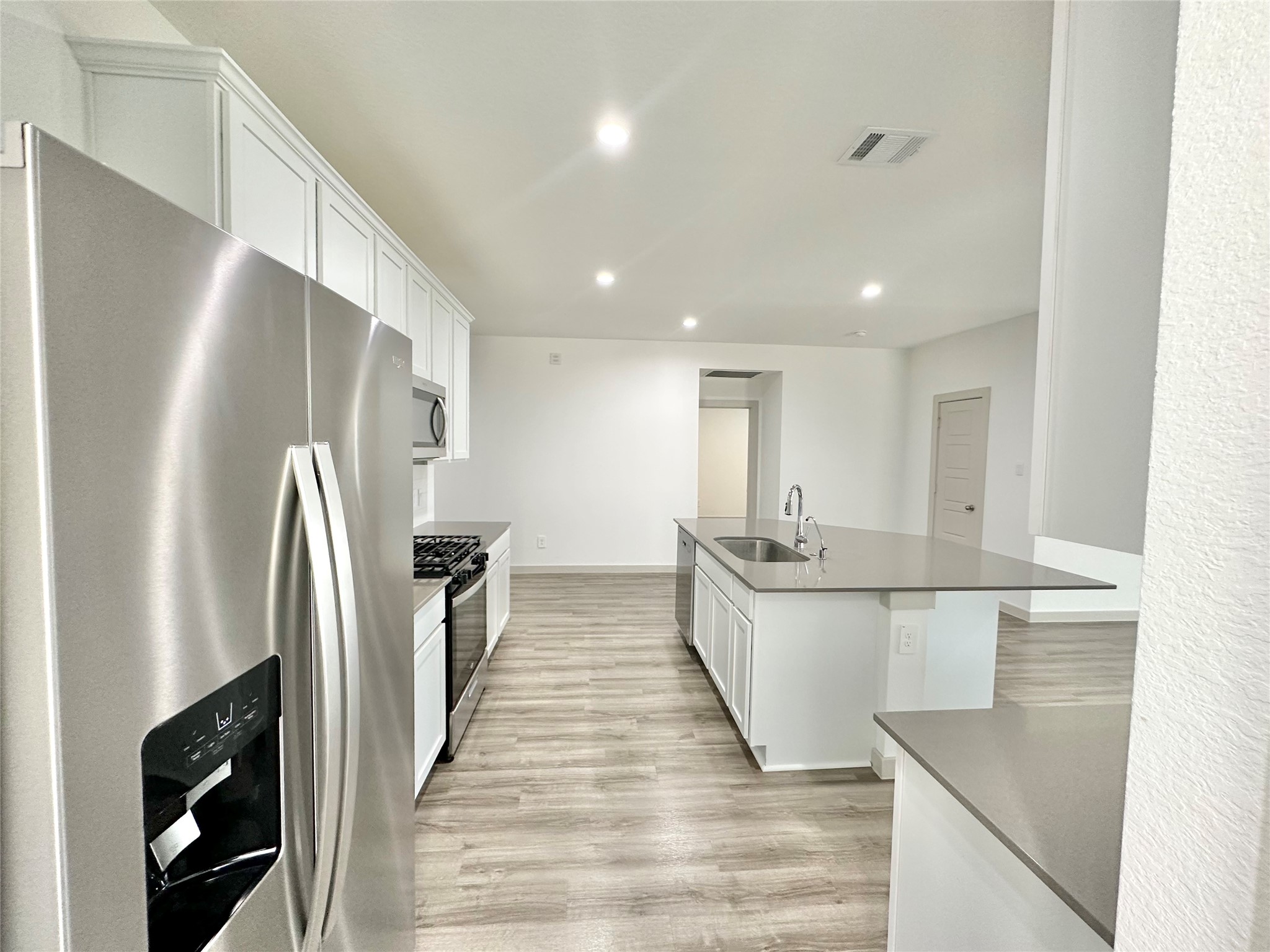 1107 Curly Angora Court Rosharon, TX 77583 - Photo 21 of 42 a large white kitchen with wooden floor and stainless steel appliances