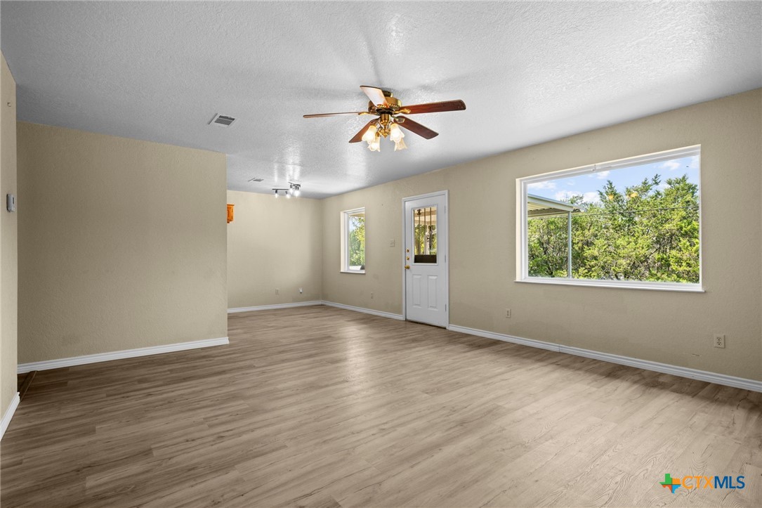 1012 Cherokee Trail Kempner, TX 76539 - Photo 12 of 27 an empty room with wooden floor chandelier fan and windows