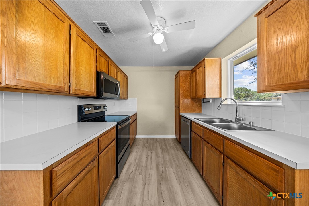 1012 Cherokee Trail Kempner, TX 76539 - Photo 19 of 27 a kitchen with stainless steel appliances wooden cabinets a sink and a stove