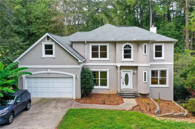 a aerial view of a house with a yard plants and large tree