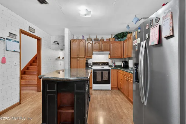 a kitchen with stainless steel appliances granite countertop a refrigerator and a stove