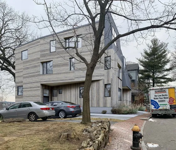 a front view of a building with parking space and a parked car