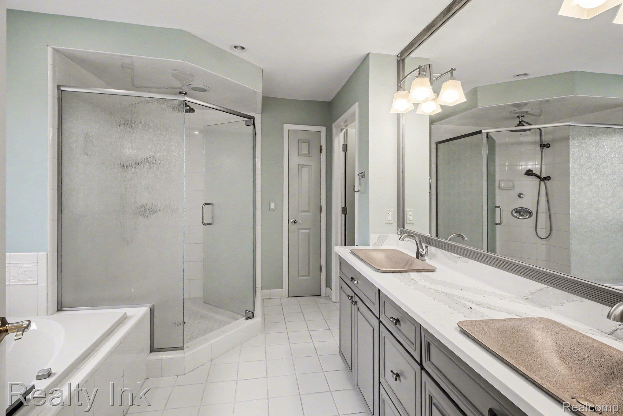 4927 Nature View Court Howell, MI 48843 - Photo 13 of 19 Bathroom with double vanity, a stall shower, light tile patterned flooring, and a garden tub