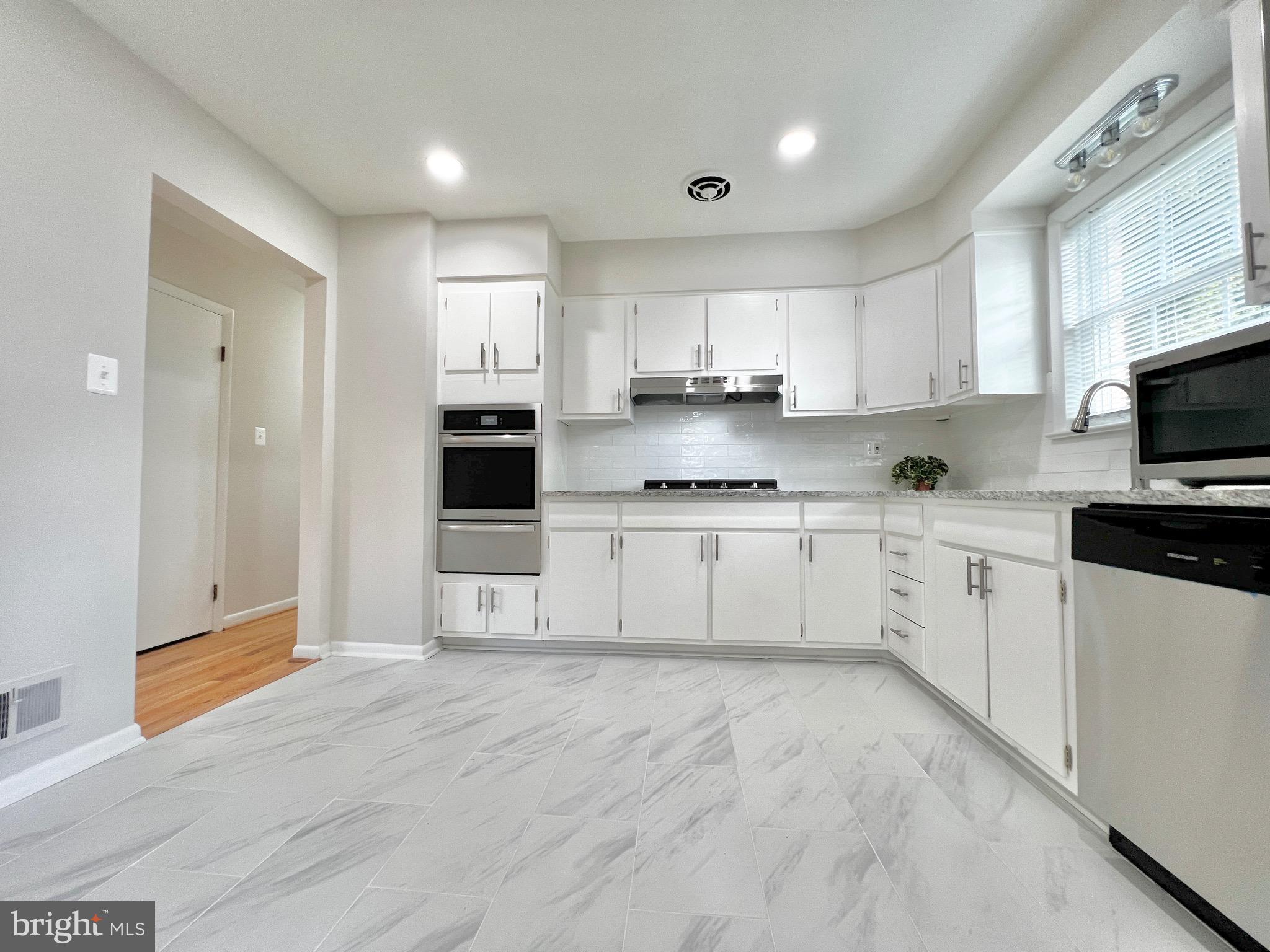 11218 Keystone Avenue Clinton, MD 20735 - Photo 16 of 53 a kitchen with stainless steel appliances a refrigerator sink and white cabinets
