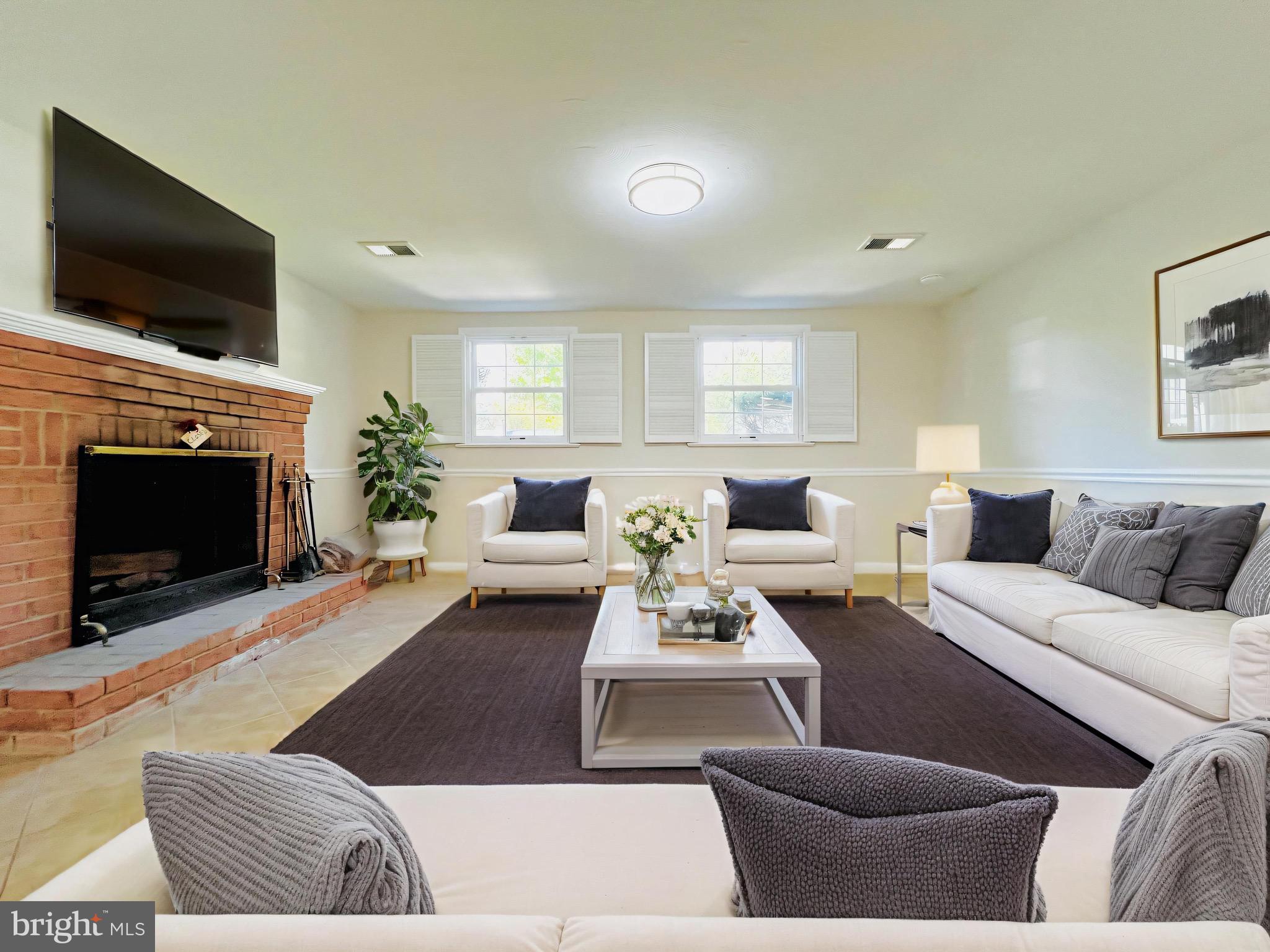 11218 Keystone Avenue Clinton, MD 20735 - Photo 34 of 53 a living room with furniture a flat screen tv and a fireplace