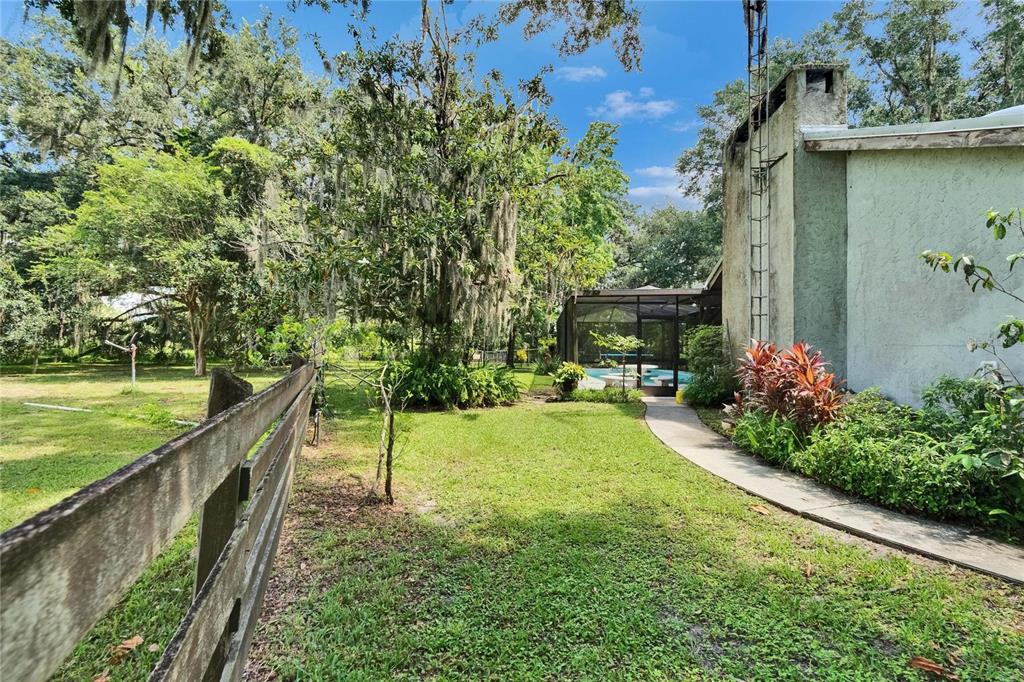 3102 East Trapnell Road Plant City, FL 33566 - Photo 28 of 100 a view of a house with a backyard and a patio