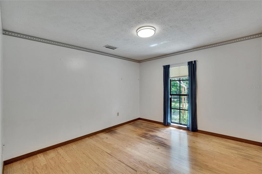 3102 East Trapnell Road Plant City, FL 33566 - Photo 83 of 100 a view of an empty room with wooden floor and a window