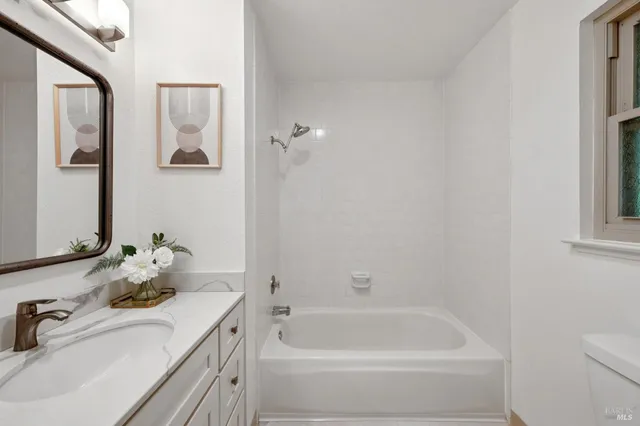 a bathroom with a tub sink and mirror