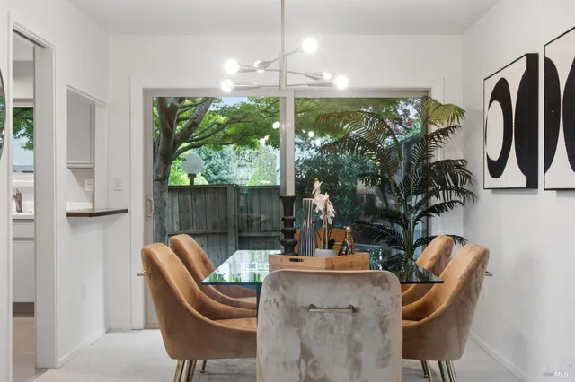 a dining room with furniture and a floor to ceiling window