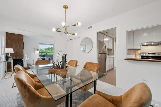 a living room with furniture a flat screen tv and kitchen view