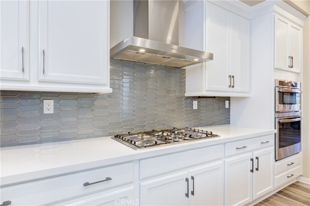 168 Spectacle Irvine, CA 92618 - Photo 11 of 42 a kitchen with white cabinets and a stove