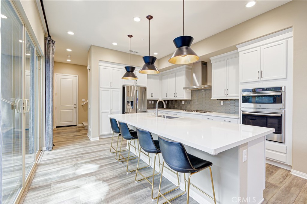 168 Spectacle Irvine, CA 92618 - Photo 12 of 42 a kitchen with a table a refrigerator a cabinets and wooden floor