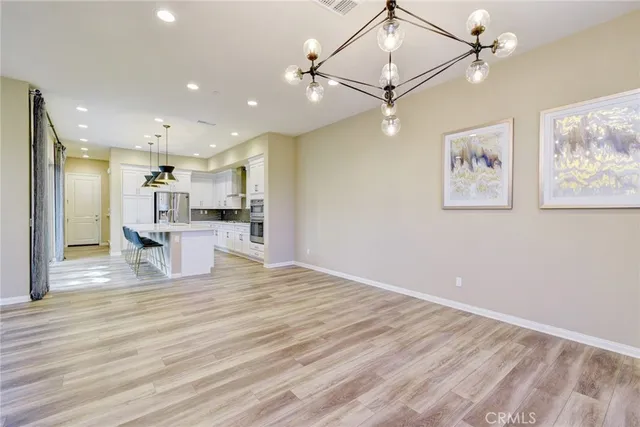 a view of a kitchen with wooden floor and a ceiling fan