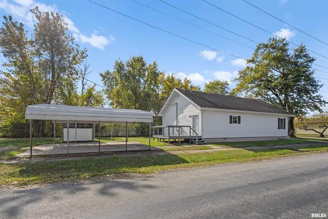 a view of a house with a big yard and large trees