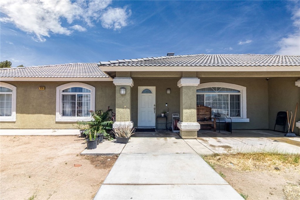 18936 Rock Springs Road Hesperia, CA 92345 - Photo 1 of 28 a view of a house with potted plants and a barbeque grill