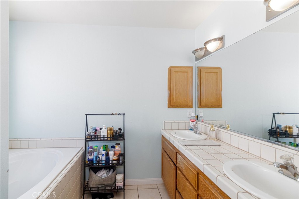 18936 Rock Springs Road Hesperia, CA 92345 - Photo 18 of 28 a en suite bathroom with a double vanity sink and a mirror