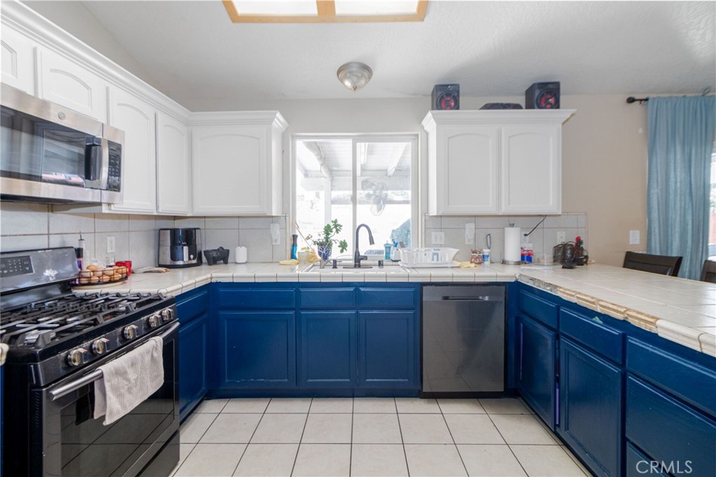 18936 Rock Springs Road Hesperia, CA 92345 - Photo 10 of 28 a kitchen with stainless steel appliances granite countertop a sink and cabinets