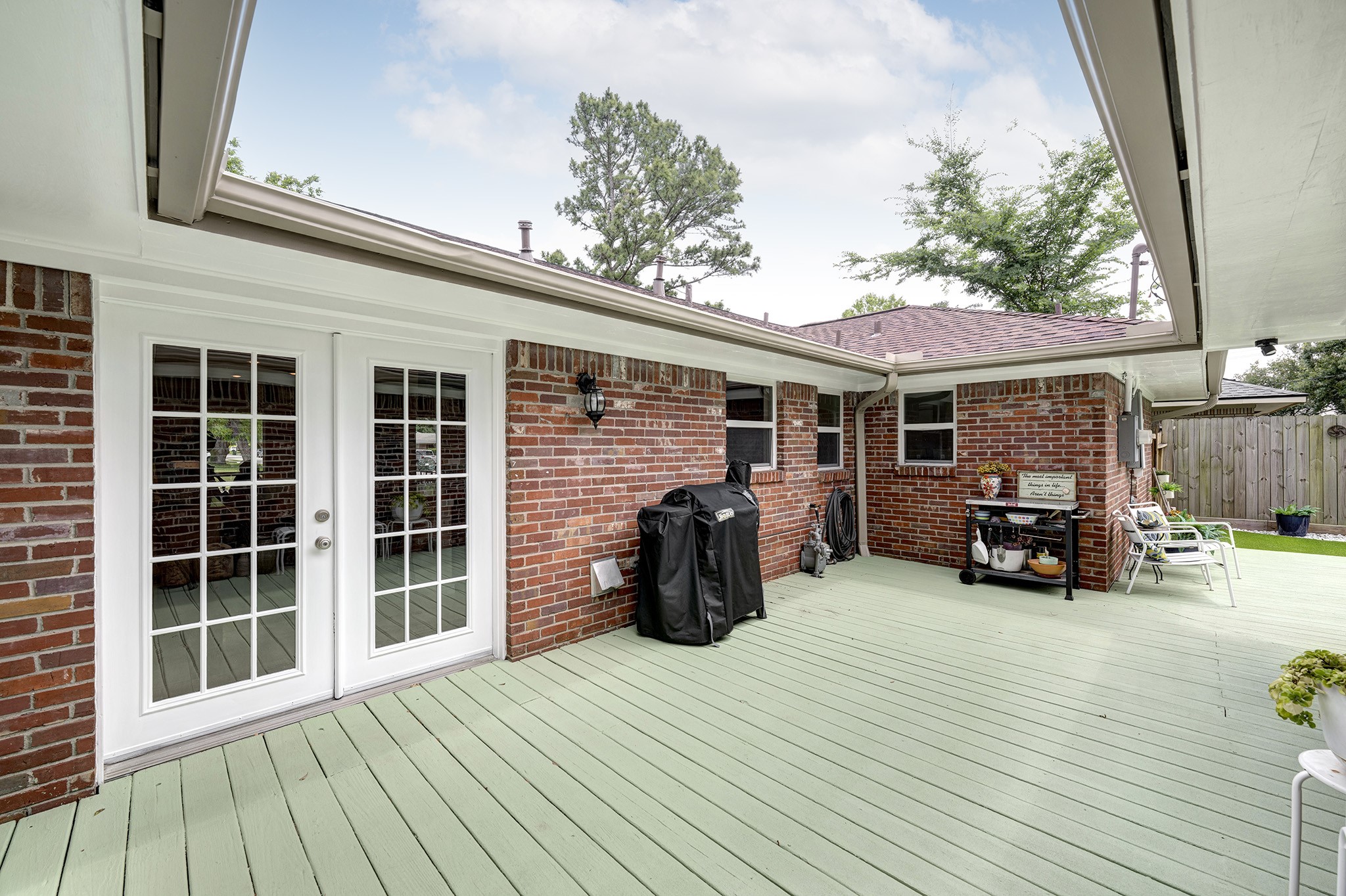 1111 Clovis Road Houston, TX 77008 - Photo 22 of 32 A portion of the deck is nestled between the family room/kitchen area and primary suite. The deep overhangs of the roof's perimeter give this space a unique sky view cut out that brings natural light to the interior of the home.