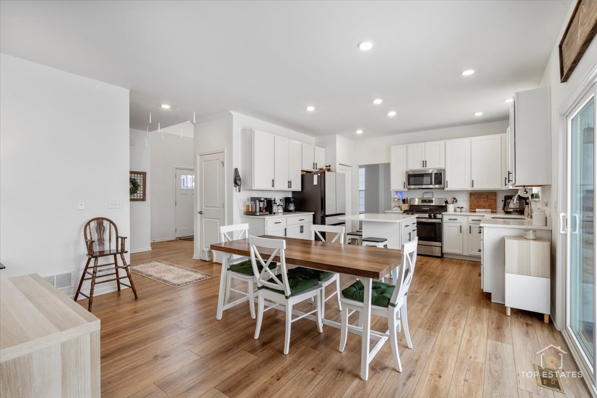 1457 Collins Street Elburn, IL 60119 - Photo 16 of 39 a view of a dining room with furniture a rug and wooden floor