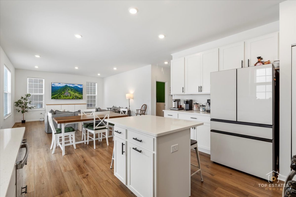 1457 Collins Street Elburn, IL 60119 - Photo 17 of 39 a kitchen with a table chairs wooden floor and stainless steel appliances