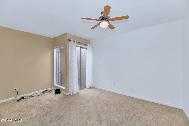 an empty room with closet and a ceiling fan
