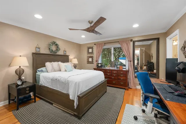 a spacious bedroom with a bed a ceiling fan and a rug