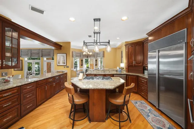a kitchen with granite countertop kitchen island stainless steel appliances a sink stove and cabinets
