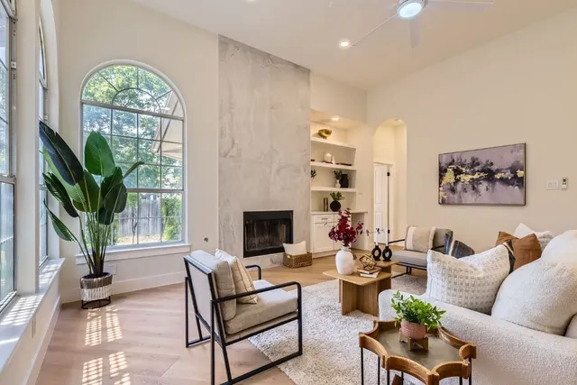 a living room with furniture a large window and a fireplace