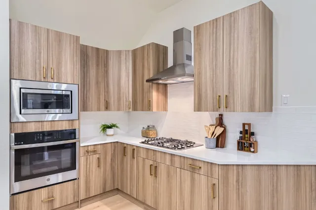 a kitchen with stainless steel appliances a stove a microwave and a cabinets