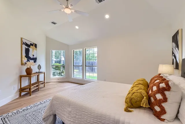 a bedroom with a bed window and a chandelier