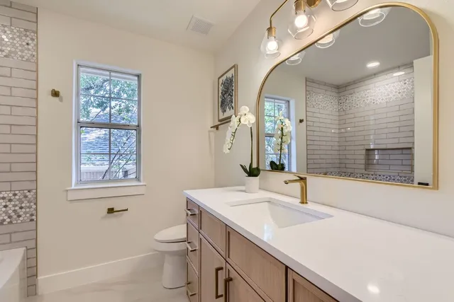 a bathroom with a sink a toilet and shower