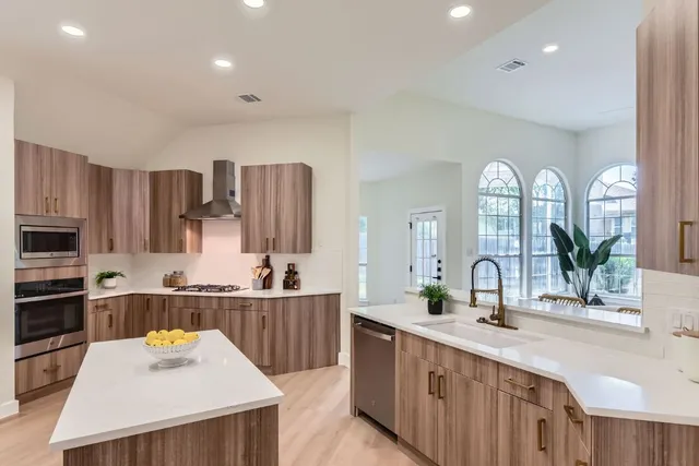 a kitchen with stainless steel appliances a sink stove and cabinets