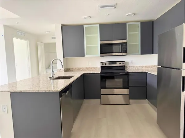a kitchen with stainless steel appliances a sink stove and refrigerator
