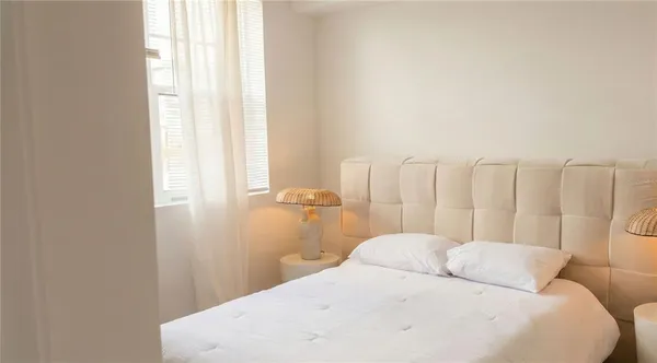 a bedroom with a white bed and a white cabinet