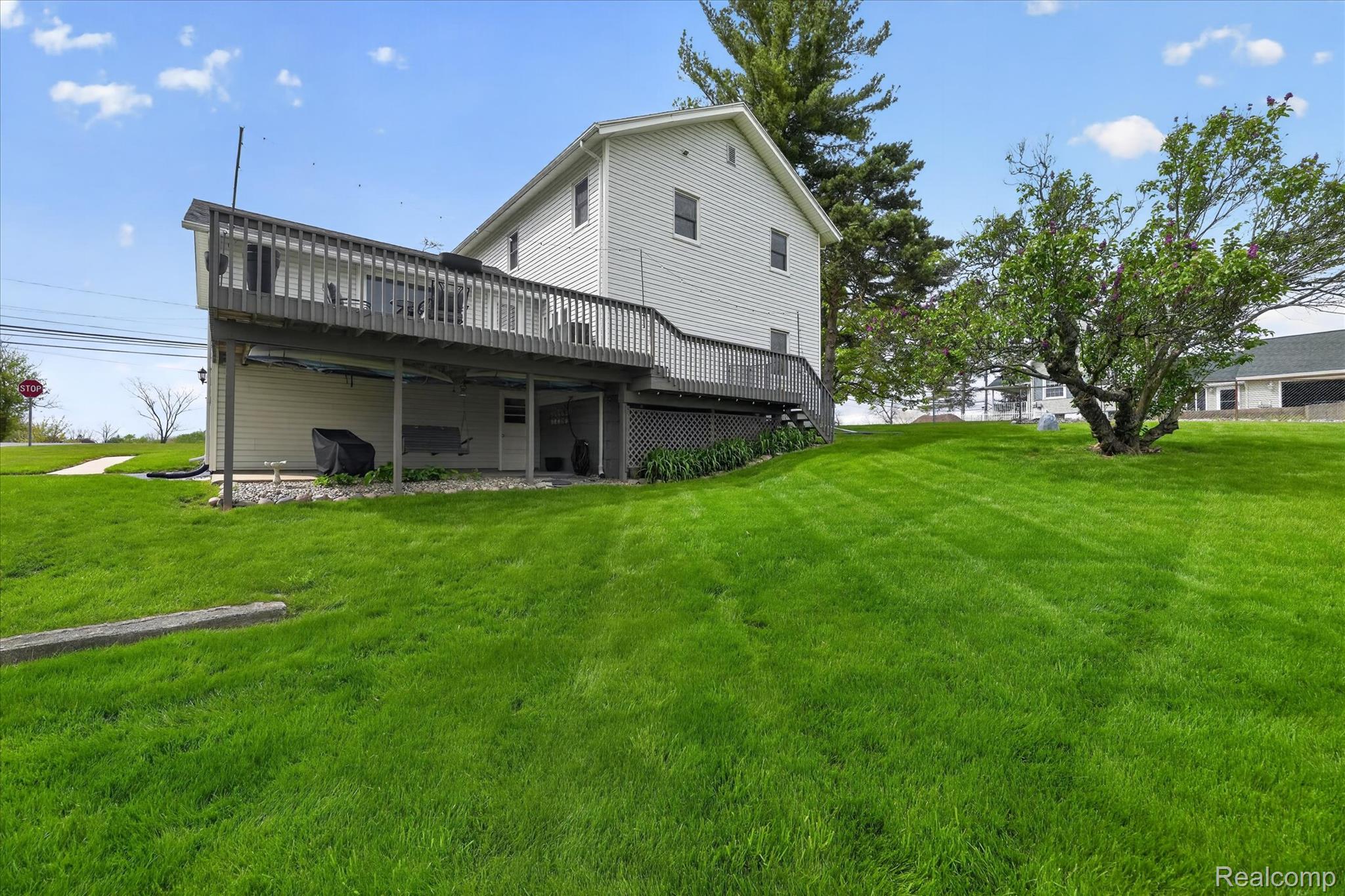 12409 Fenton Road Fenton, MI 48430 - Photo 34 of 61 Back of property with a wooden deck and a yard