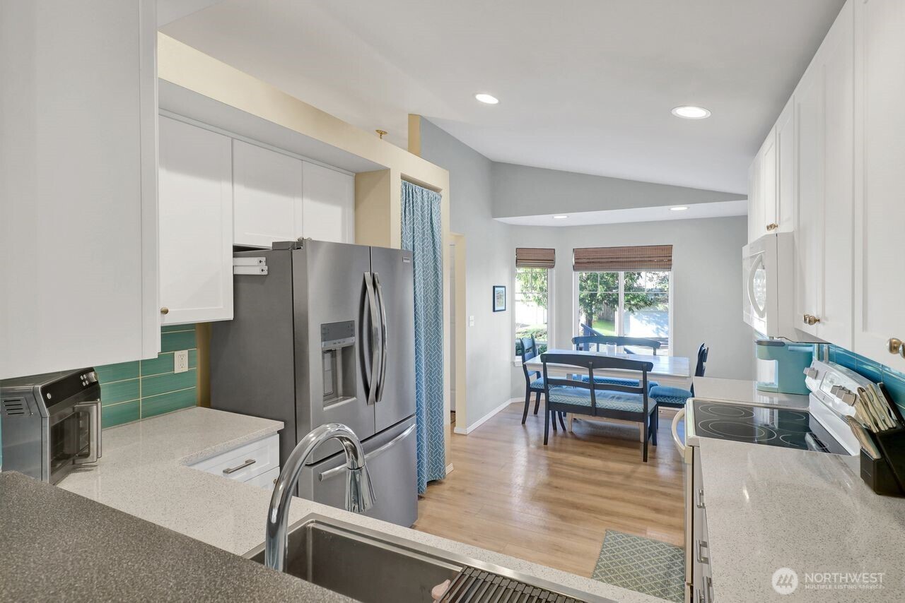 840 Nevada Street Bellingham, WA 98229 - Photo 11 of 38 a kitchen with stainless steel appliances a refrigerator a table and chairs