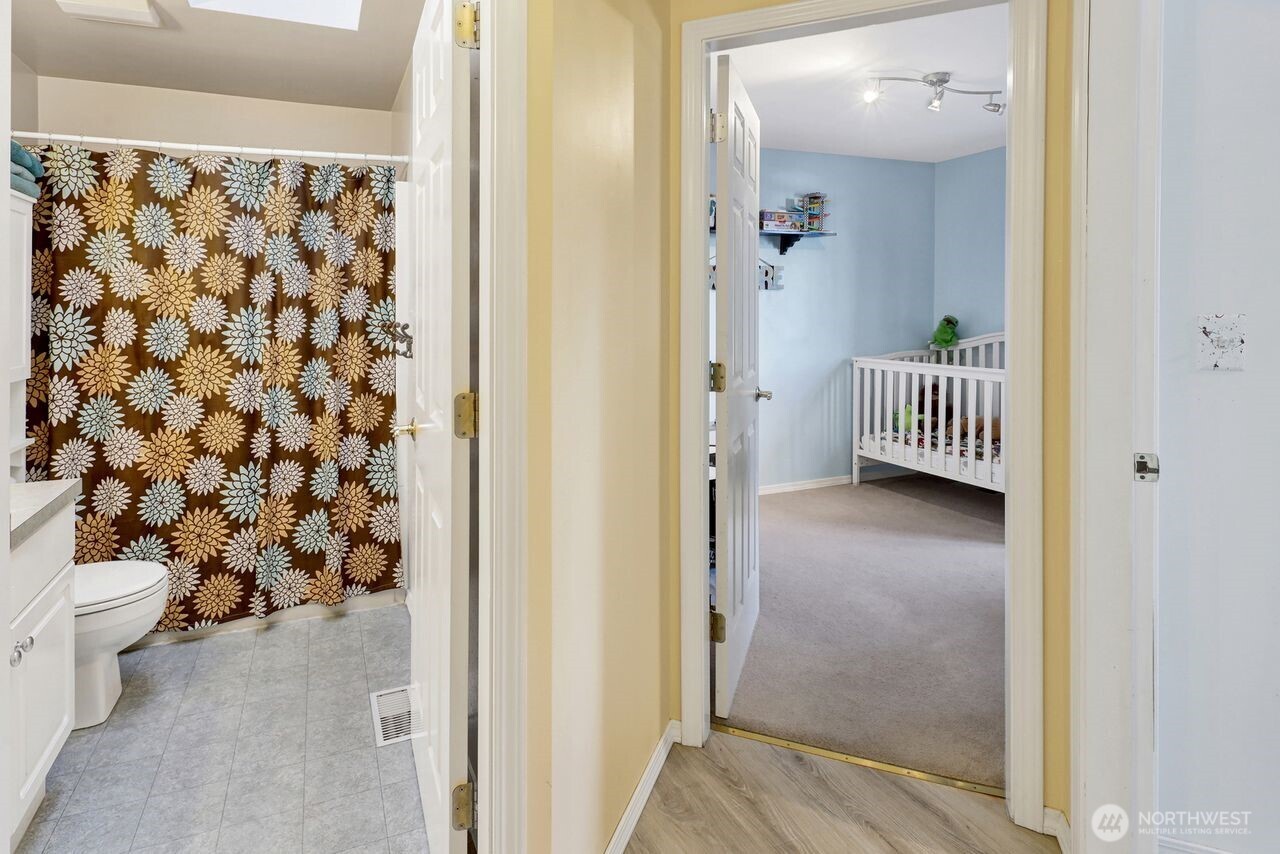 840 Nevada Street Bellingham, WA 98229 - Photo 19 of 38 a view of a hallway with wooden floor and a bathroom