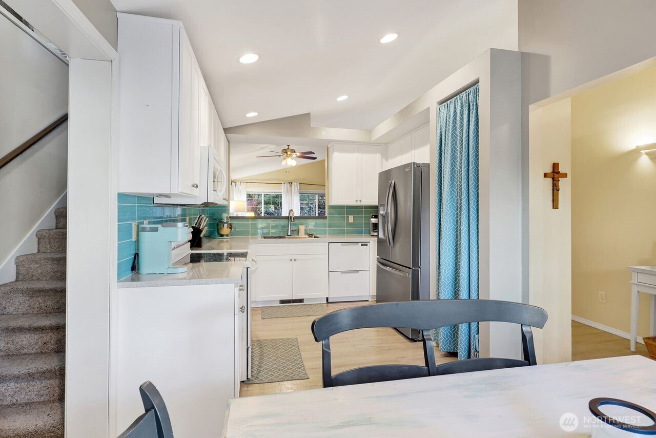 840 Nevada Street Bellingham, WA 98229 - Photo 7 of 38 a kitchen with stainless steel appliances kitchen island granite countertop a refrigerator a stove and a sink with granite countertops