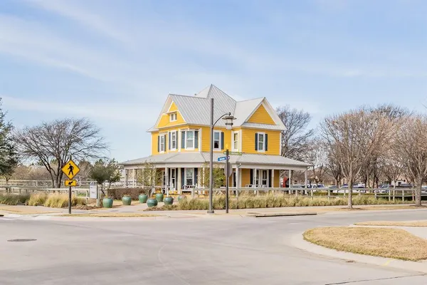 a front view of residential houses with yard and trees