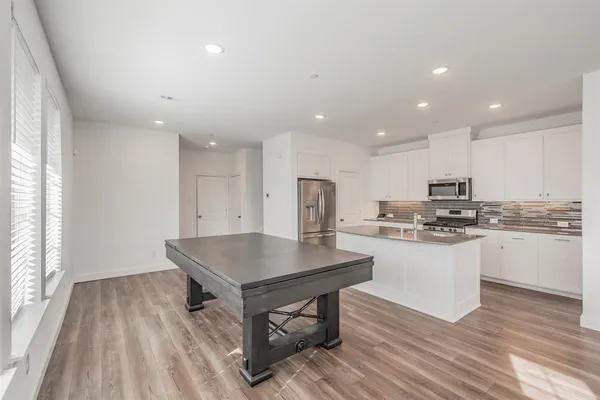 a kitchen with kitchen island sink stove and refrigerator