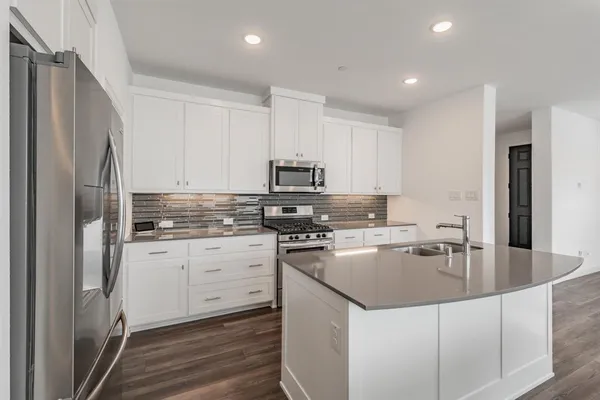 a kitchen with granite countertop a refrigerator stove and sink