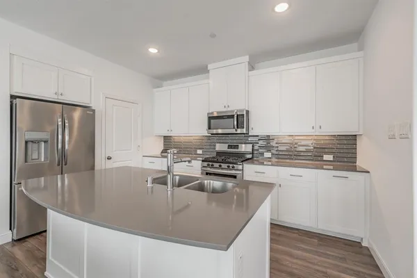 a kitchen with stainless steel appliances granite countertop a sink stove and refrigerator