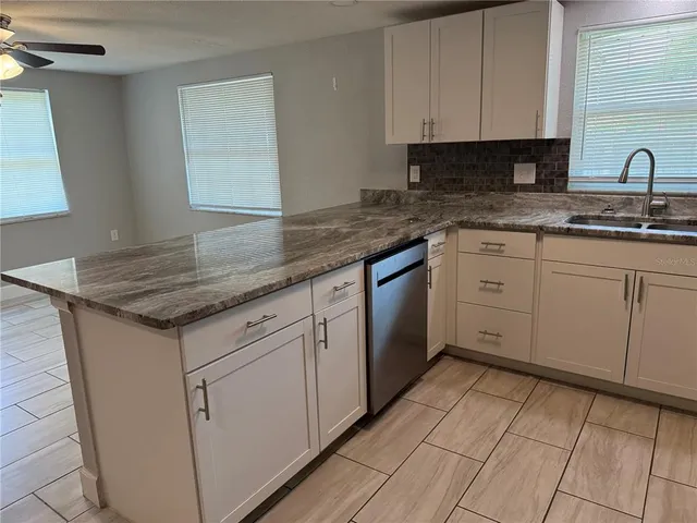 a kitchen with stainless steel appliances granite countertop a refrigerator sink and stove