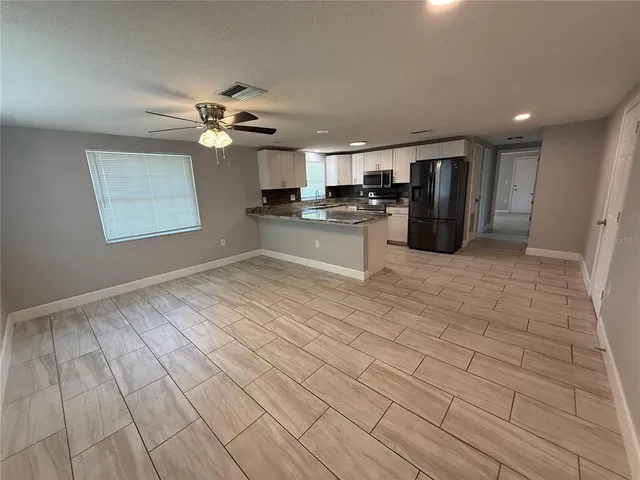 a kitchen with stainless steel appliances granite countertop a refrigerator a stove a sink and a microwave