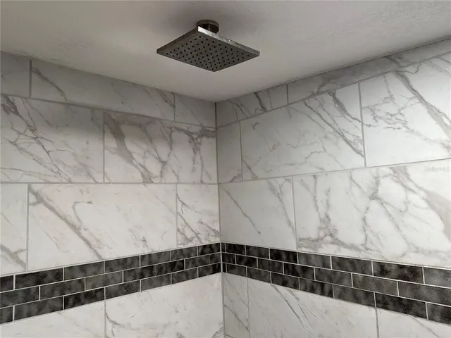 a bathroom with a granite countertop sink a mirror and a bathtub