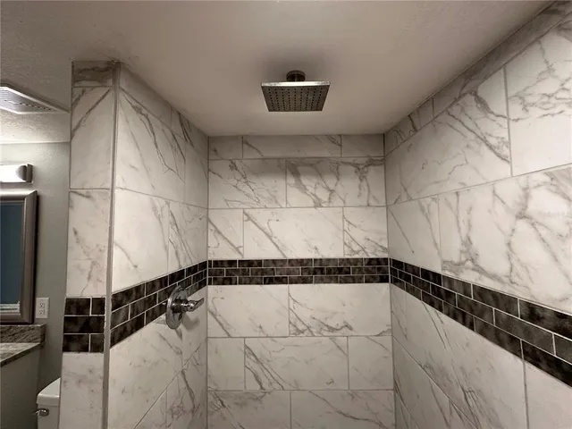 a bathroom with a granite countertop toilet sink and mirror