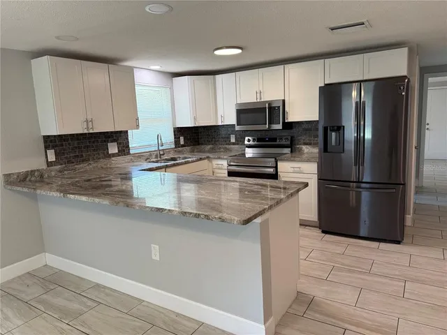 a view of a kitchen with wooden floor and a window