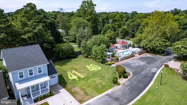 an aerial view of a house with a garden and large trees
